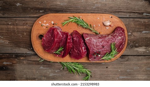 Beef Tenderloin fillet with rosemary and spices. Preparing fresh beef steak ready to cook, Long banner format. Restaurant menu, dieting, cookbook recipe. place for text. top view. - Shutterstock ID 2153298983