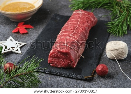 Beef tenderloin, tied with kitchen string and prepared for roasting. Holiday dishes. Cooking beef in the oven as a whole piece. Merry Christmas. Step-by-step recipes.