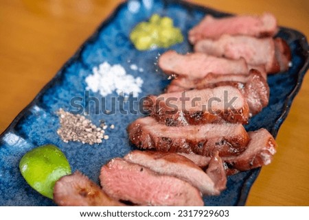 Beef tongue meat served on plate with salt, pepper and lime