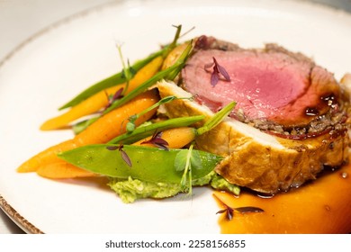 Beef Wellington with Sautéed Baby Carrots and Green Beans, Plated on a White Dish - Shutterstock ID 2258156855