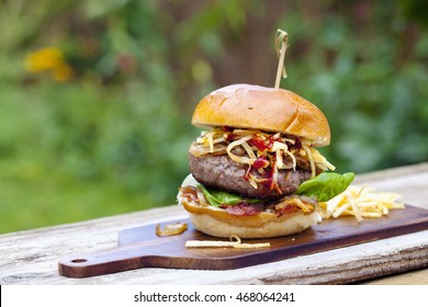 Beefburger With Fried Onions, Bacon And String Fries In Brioche Bun