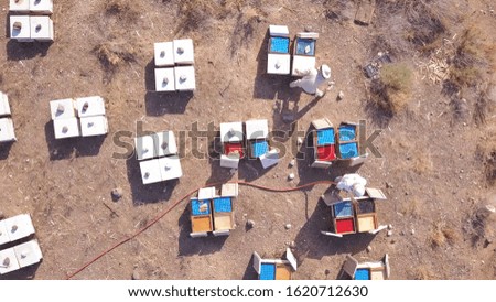 Beekeeper performs hive maintenance work. Aerial view of Bee Keepers while working in the hive.