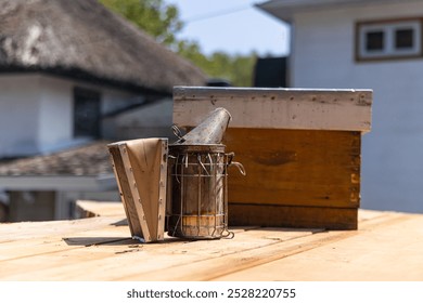 Beekeeping equipment sitting on a wooden surface, ready for a beekeeper to use for hive maintenance. Selective focus - Powered by Shutterstock