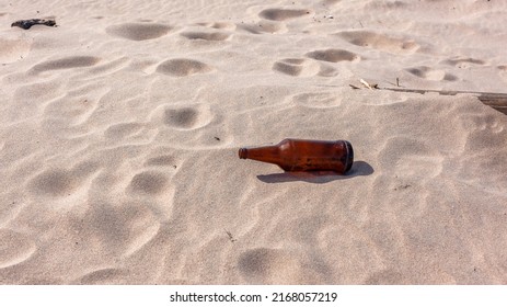 Beer Alcohol Bottle Empty Left On Beach Sand .