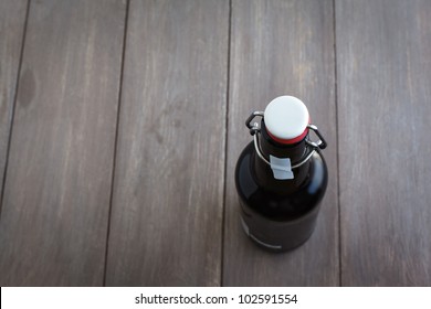 Beer bottle on brown planks.