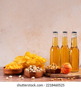 Beer In Bottle And Snack On Wooden Table With Basketball Ball, Game Night Food. Snack And Drink For Watching Sport Games And Championships