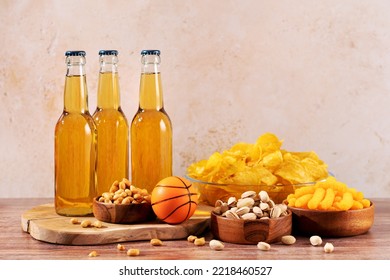 Beer In Bottle And Snack On Wooden Table With Basketball Ball, Game Night Food. Snack And Drink For Watching Sport Games And Championships