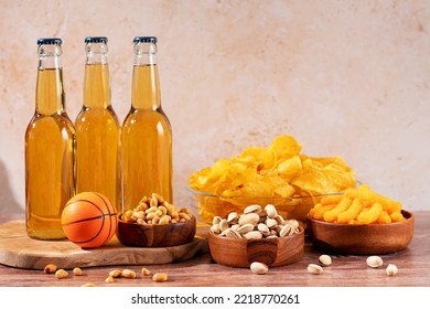 Beer In Bottle And Snack On Wooden Table With Basketball Ball, Game Night Food. Snack And Drink For Watching Sport Games And Championships