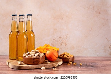 Beer In Bottle And Snack On Wooden Table With Basketball Ball, Game Night Food. Snack And Drink For Watching Sport Games And Championships