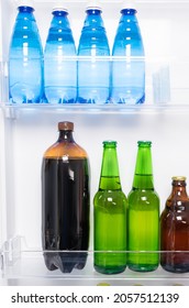 Beer And Bottled Water Stand On The Shelves In The Refrigerator Door, Front View