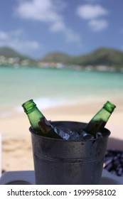 
Beer Bottles In An Ice Bucket In Front Of A Sunny Beach