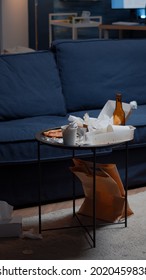 Beer Bottles And Pizza On Table In Messy Living Room With Nobody In, Leftover Thrown On Floor. Unorganized House Apartment Of Alone Woman With Sever Depresion Having Trash, Rubbish