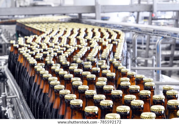 beer filling in a brewery - conveyor belt with\
glass bottles