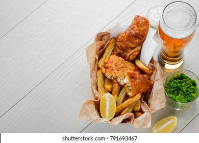 Beer to fish and fries. Addition of mashed green peas and lemon. Traditional British cuisine.