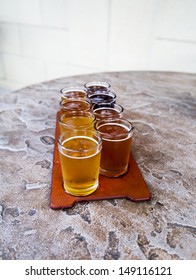 Beer Flight Of Eight Sampling Glasses On A Serving Paddle