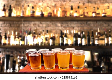 Beer Flight Of Eight Sampling Glasses Of Craft Beer On A Bar Countertop.