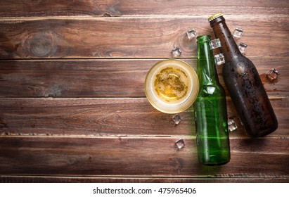 Beer glass with bottle cap and bottle on rustic wood background,space for text,top view