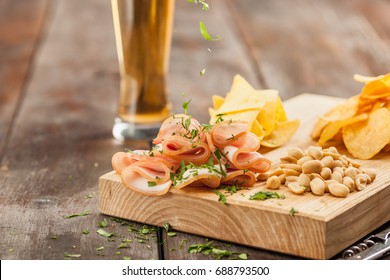 Vidrio de cerveza y papas fritas, pistachos aislados en blanco Foto de stock