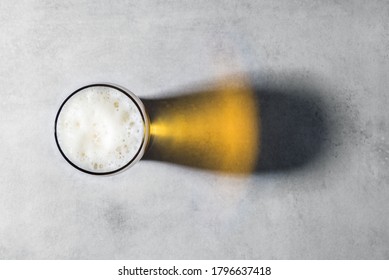 Beer Glass And Shadows, Top View On Gray Concrete Background With Copy Space, Conceptual Minimalism, Flat Lay