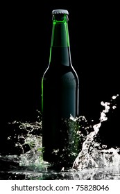 Beer In Green Bottle With Water Splash Isolated On Black