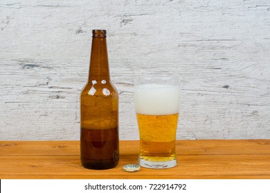 Beer Half Empty Bottle And Full Glass On Pub Table
