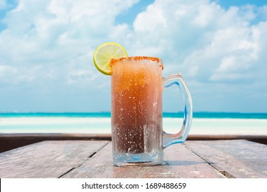 Beer jar with a lemon slice on a blue sky with clouds