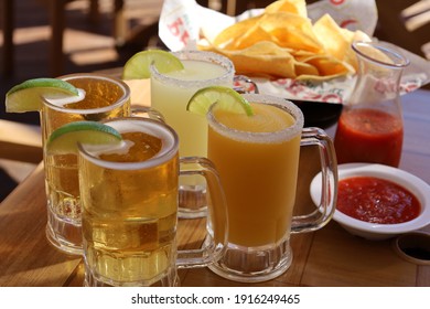 Beer And Margaritas On A Table With Chips And Salsa In The Sunlight 