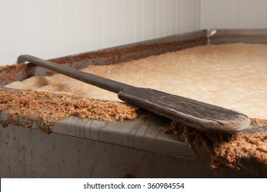 Beer Mash Into The Fermentation Vessel And A Mixing Spatula