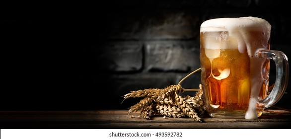 Beer in mug on wooden table near brick wall - Powered by Shutterstock