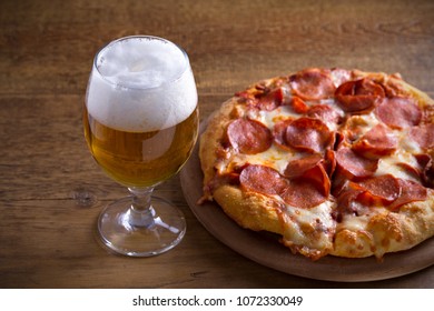 Beer and pepperoni pizza on wooden table. Glass of beer. Ale and food concept. horizontal - Powered by Shutterstock