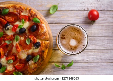 Beer and pizza on wooden plate. Ale and  snack. Overhead, horizontal - Powered by Shutterstock