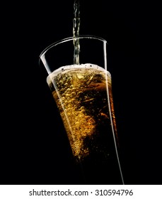 Beer Poured Into A Glass On A Black Background
