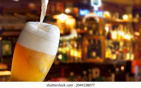 beer pouring into glass in a bar - Powered by Shutterstock