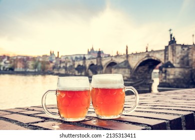 Beer in Prague, Czech Republic with view on Charles Bridge at sunset - Shutterstock ID 2135313411