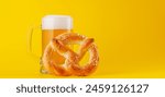 Beer and pretzel. Over yellow background with copy space