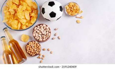 Beer And Snack On Gray Table Top With Football Ball, Football Game Night Food, Copy Space. Snack And Drink For Watching Football Games And Championships