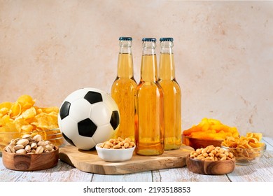 Beer And Snack On Wooden Table With Football Ball, Football Game Night Food. Snack And Drink For Watching Football Games And Championships