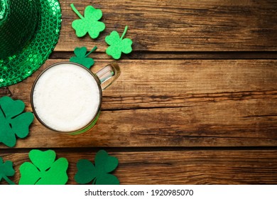 Beer and St Patrick's Day decor on wooden table, flat lay. Space for text