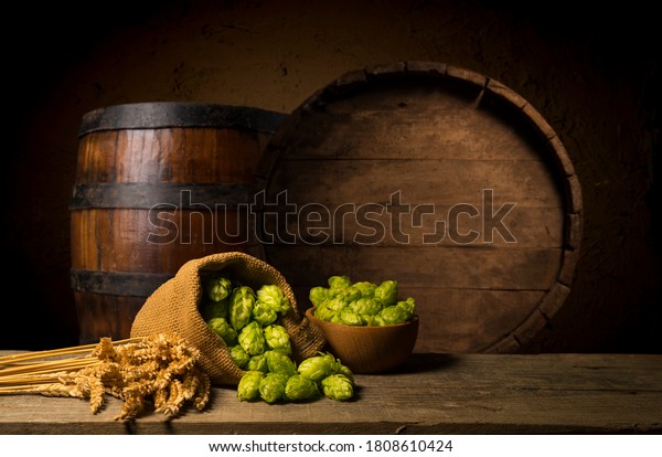 Beer. Still\
life with Vintage beer barrel and glass light beer. Fresh amber\
beer concept. Green hop and gold barley on wooden table.\
Ingredients for brewery. Brewing\
traditions