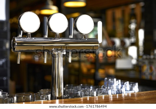 Beer tap in\
bar, mock up with selective\
focus.