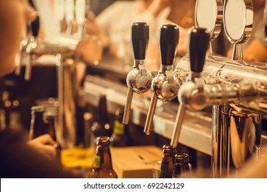 Beer tap with fresh brewed drink in busy pub in Europe. - Powered by Shutterstock