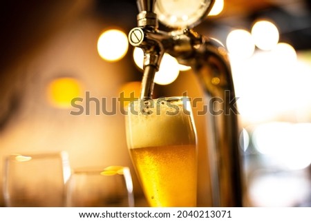 Similar – Image, Stock Photo Detail of a bartender opening a bottle of beer using a bottle opener at a bar counter.