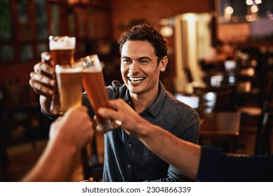 Beers, cheers and man drinking with friends at social event in a restaurant with happiness. Alcohol, glasses and toast at a pub at happy hour with smile and conversation with drinks and celebration - Powered by Shutterstock