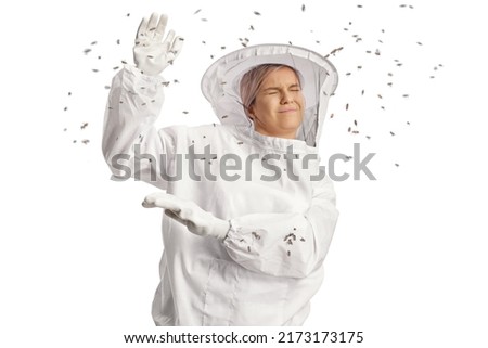 Bees attacking a young female bee keeper in a uniform isolated on white background