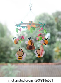 Bees And Beehive-themed Beautiful Baby Crib Mobile Hanging. Plush And Cute Bees With Flowers And Leaves. Felt Cot Mobile Close Up.