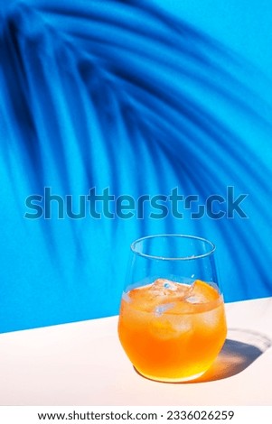 Bee's Knees alcoholic cocktail drink with dry gin, lemon juice and honey syrup, summer blue bright background, hard light and shadows