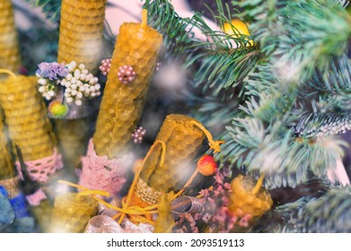 Beeswax candles decorated in Christmas style and a twig tree. Design for the new year. Selective focus