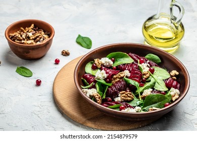 Beet Or Beetroot Salad With Baby Spinach, Cheese, Nuts, Cranberries On Plate With Fork, Dressing And Spices On Light Background, Food Recipe Background. Close Up.