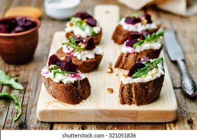 Beet Goat Cheese Arugula Walnut Honey Crostini. Toning. Selective Focus