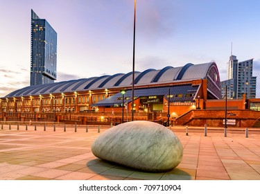 Beetham tower and Manchester train station besides a big rock lying on ground